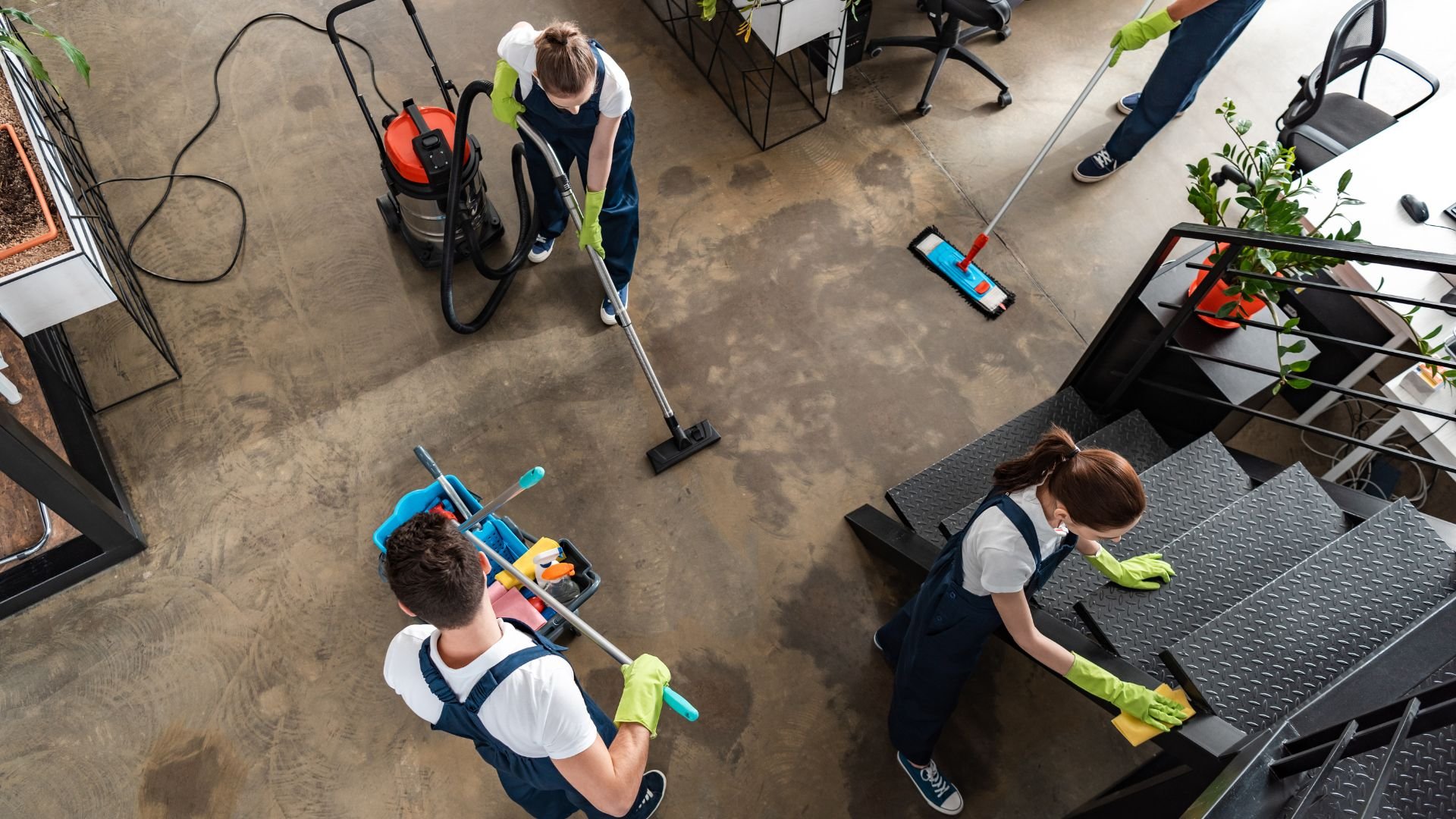Cleaning staff using vacuum and mop to clean an industrial office floor